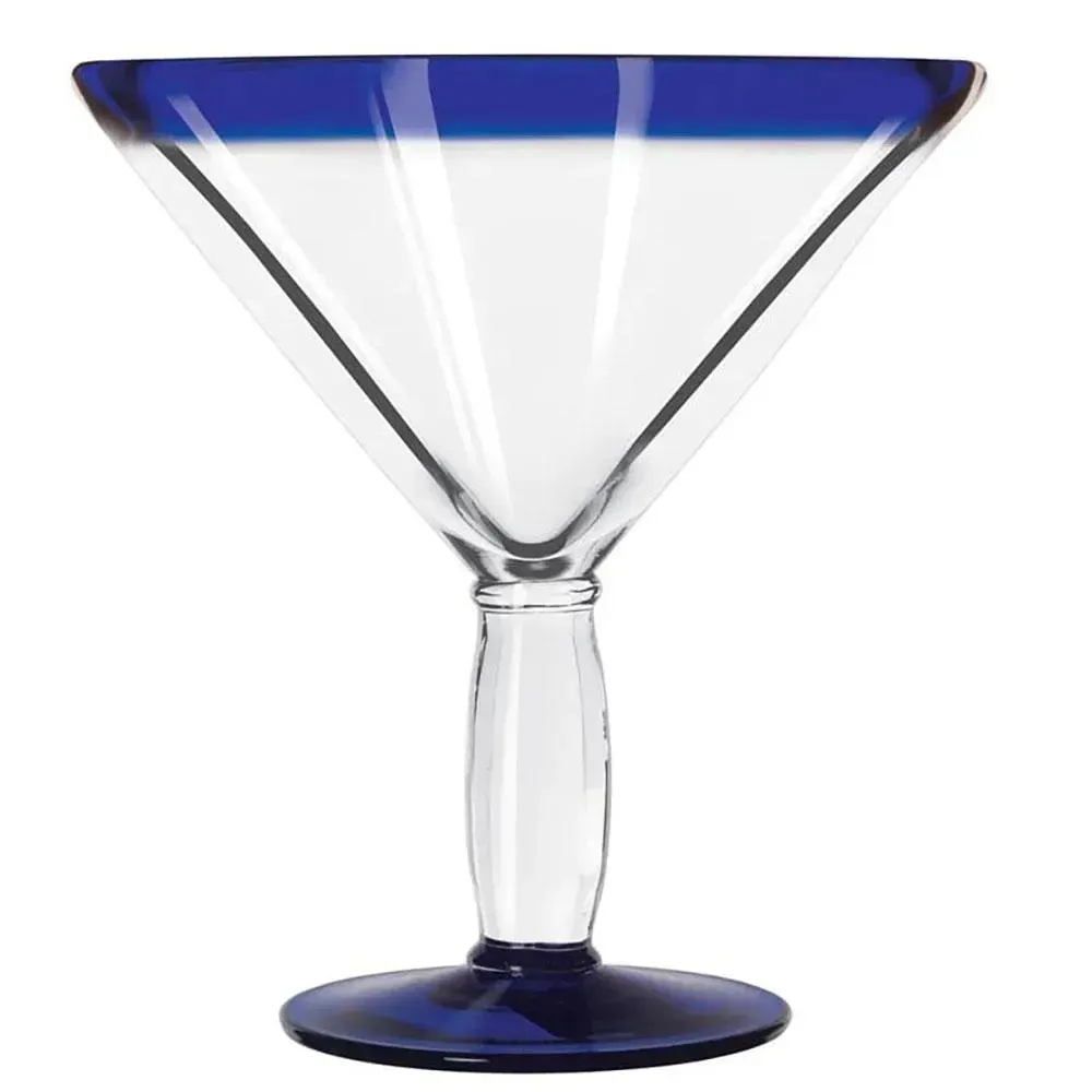 Vibrant cobalt rim martini glass from Libbey with sapphire gin and an olive set against an ocean backdrop with a glowing sunset.