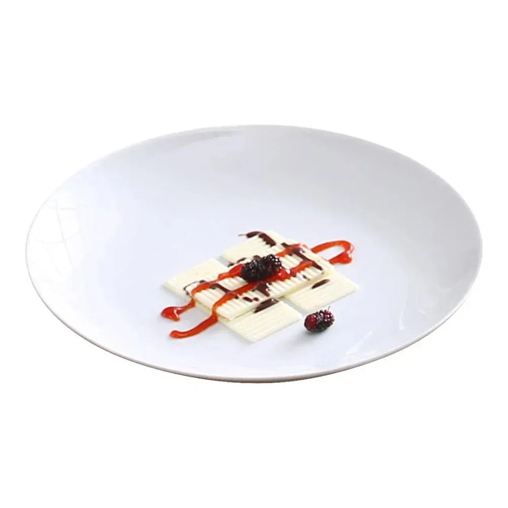 Classic white chinaware coupe plate from Yanco China on a slate board with grilled vegetables, showcasing minimalist modern plating style.