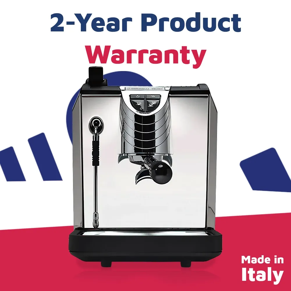 Nuova Simonelli pour-over espresso machine in glossy black with curved stainless sides sits on a wooden bar under soft morning café lighting.