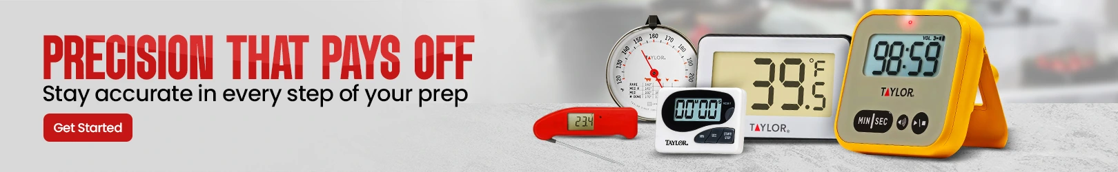Assortment of digital and analog kitchen timers and thermometers displayed on a light grey countertop with a blurred kitchen background.